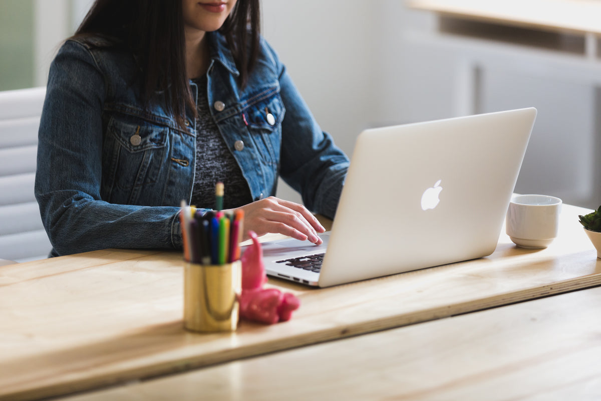 A woman working on a laptop at an office desk