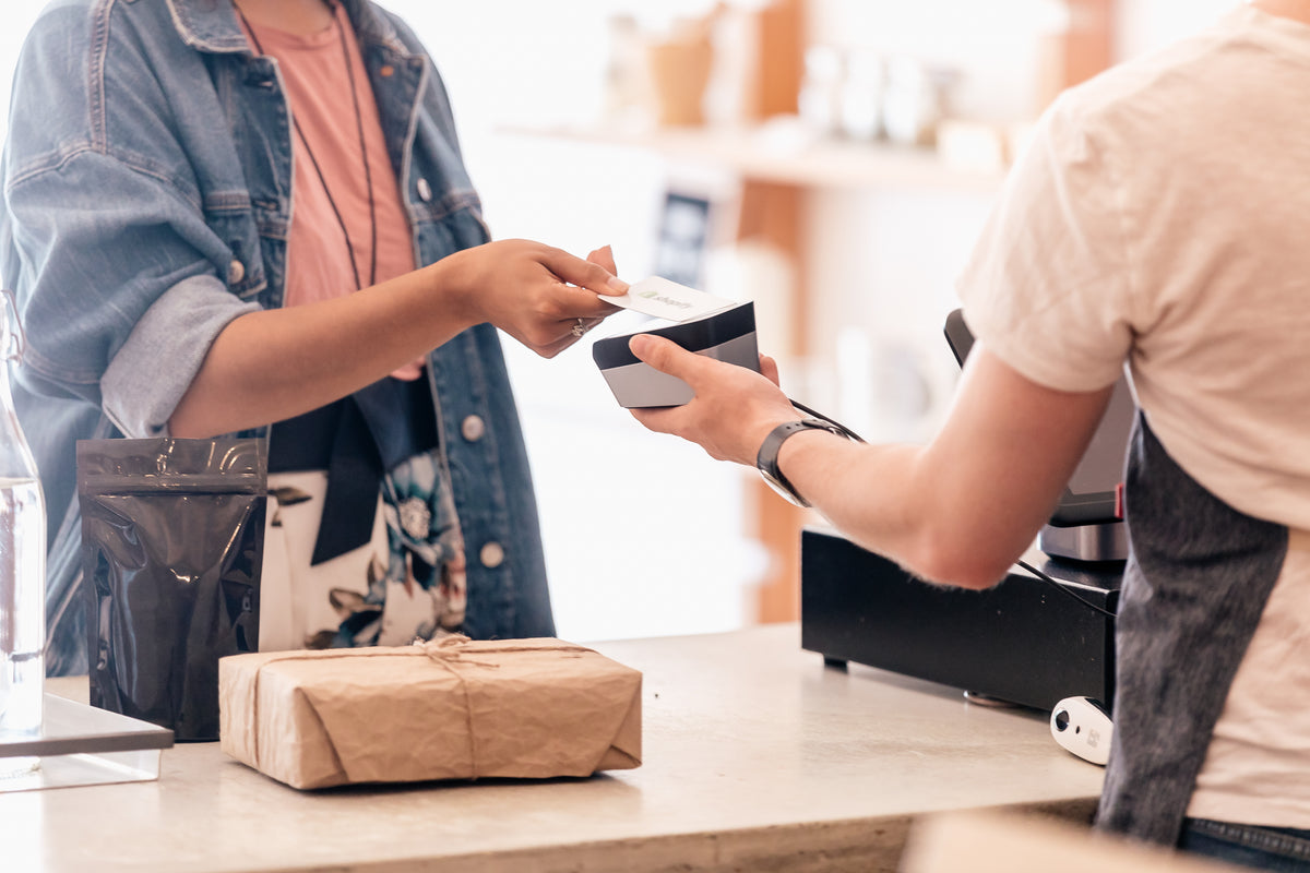 A customer paying by card at a shop counter