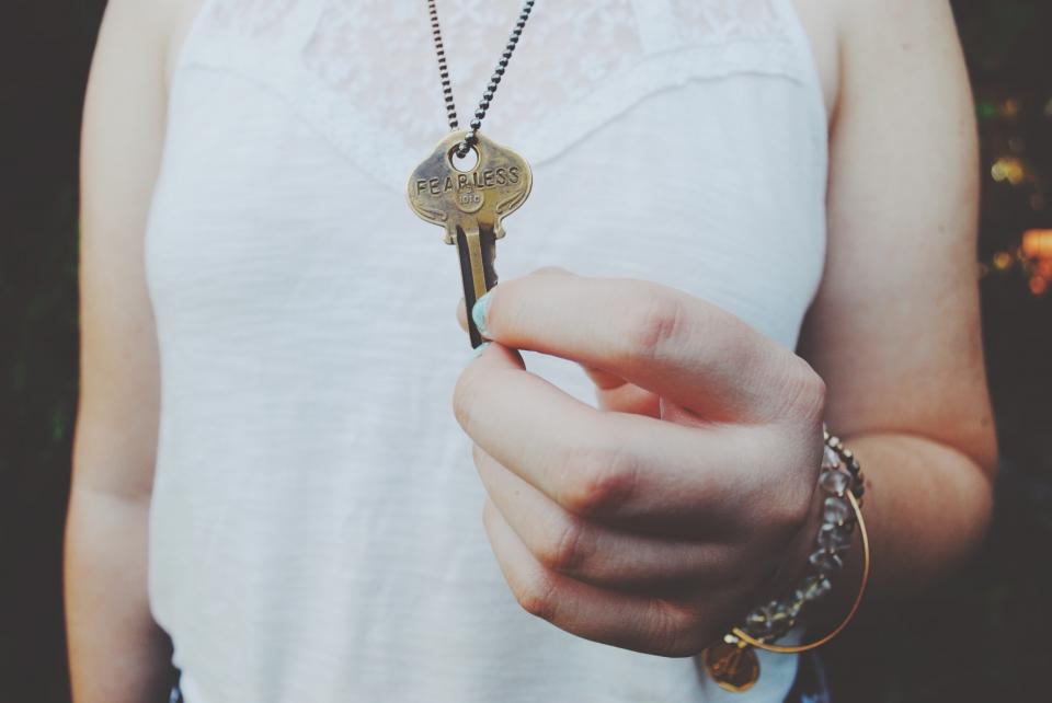 A woman holding up a door key