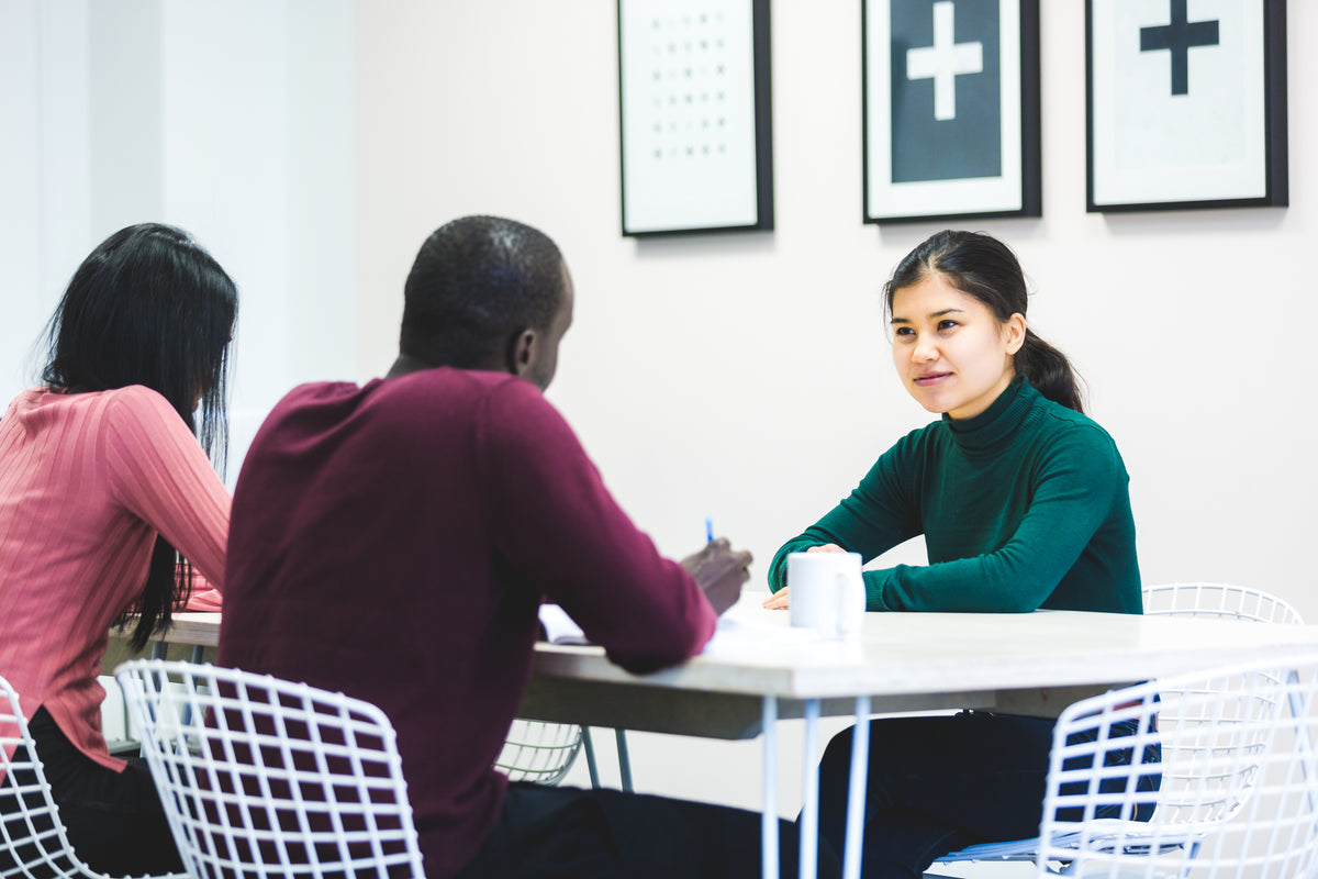 A candidate being interviewed by two people at a table