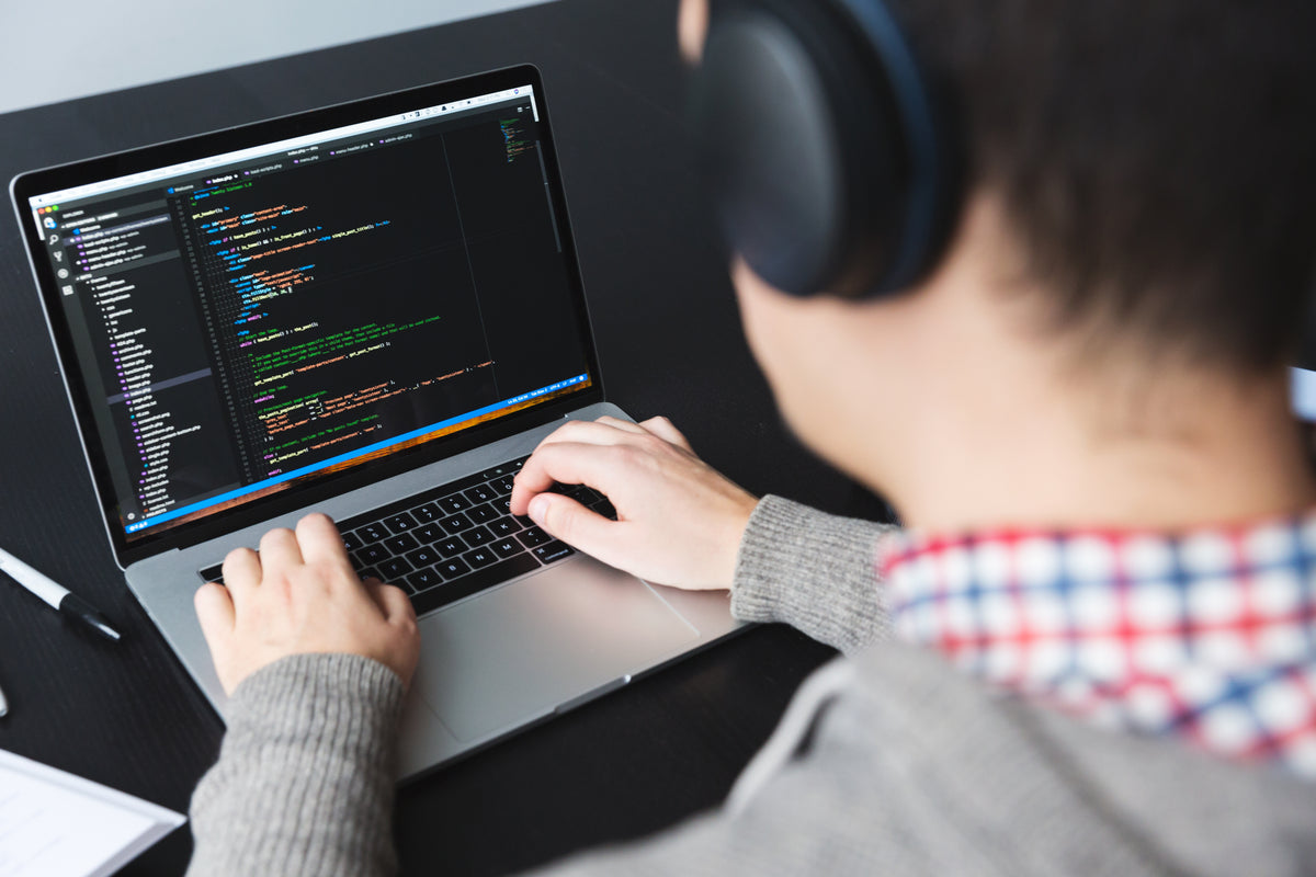 A developer writing code on a laptop