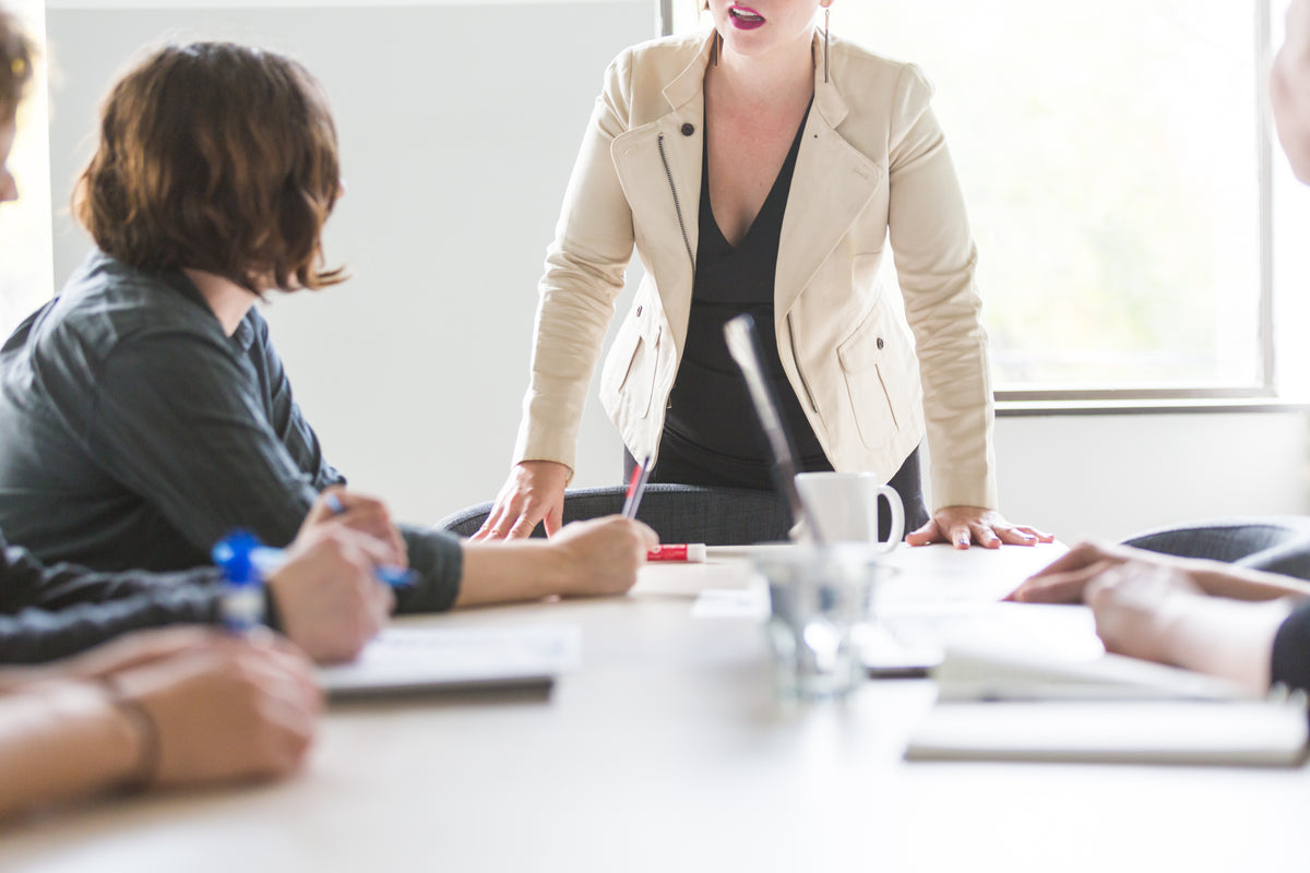 A woman leading a meeting from the head of the table